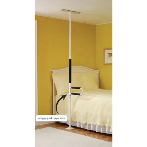A white transfer pole is shown installed between a floor and ceiling. The pole is positioned next to a bed with yellow bedding in a room with yellow walls. A black, cushioned grip is attached to the pole, and below that, a U-shaped silver metal handle (identified as a "swing grip") extends outward.