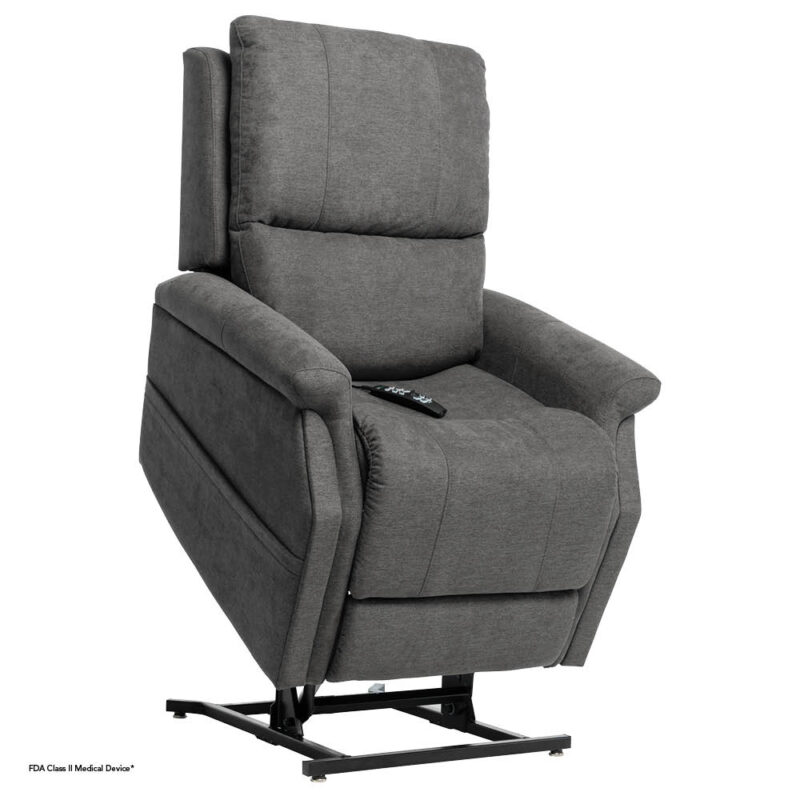 The image shows a motorized lift chair. It is upholstered in a gray fabric and is partially reclined, tilted forward, and slightly elevated to aid a person in standing up. A remote control is visible on the seat cushion.